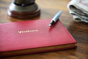 Photo of a visitor guest book and pen