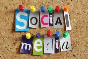 Photo of the words social media from cutout newspaper letters pinned to a cork bulletin board